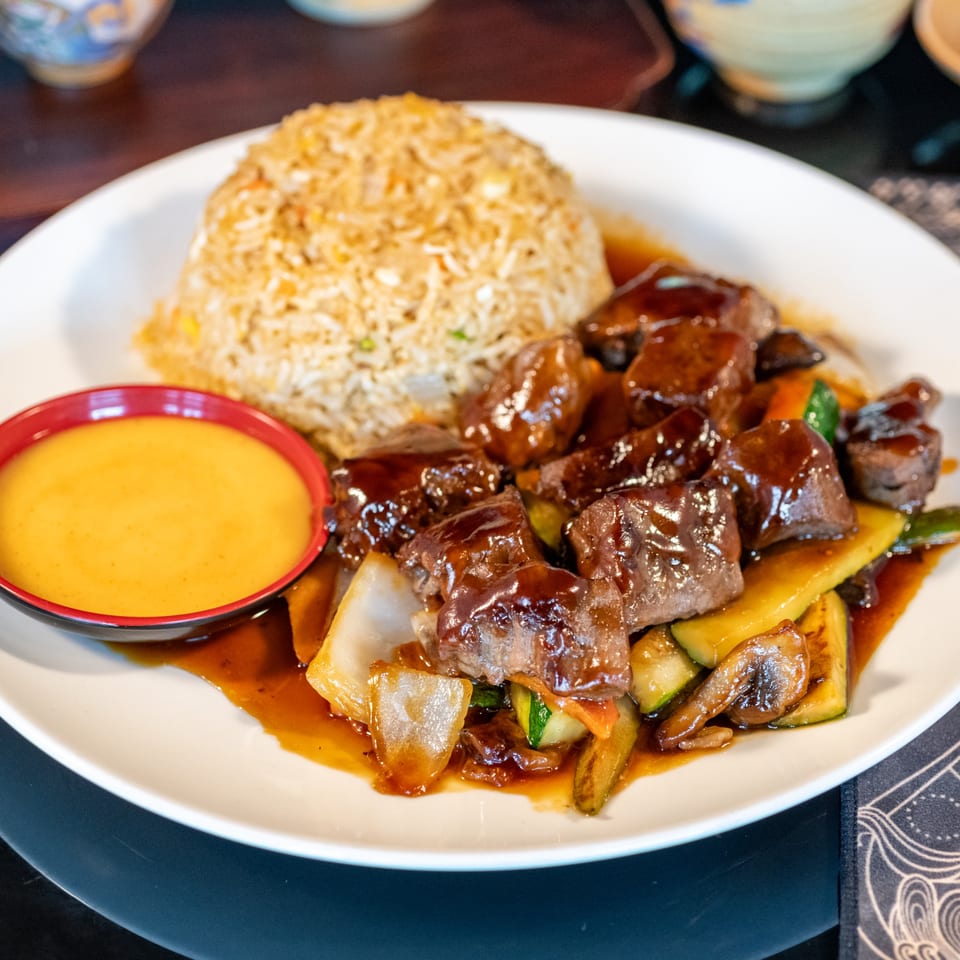 Bamboo House's beef and vegetable stir-fry with fried rice and a side of yellow sauce.